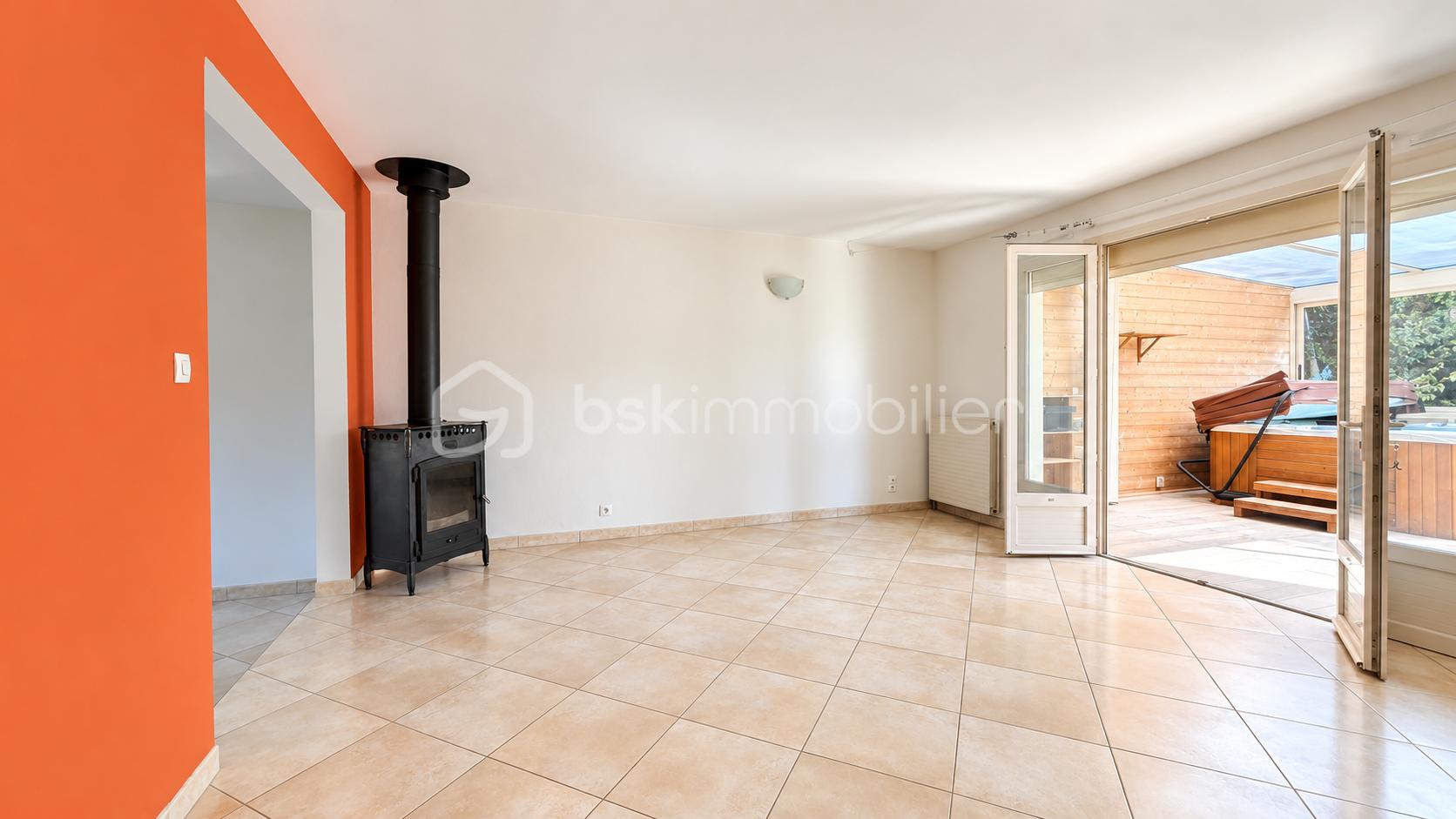 Salon lumineux avec poêle et terrasse ouverte.png