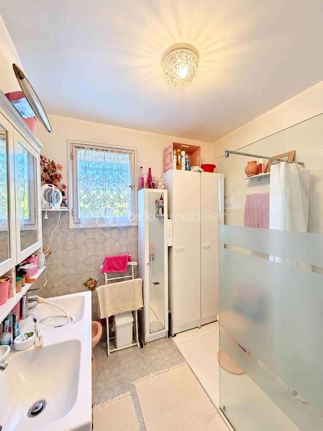 Salle de bain lumineuse avec douche vitrée.png