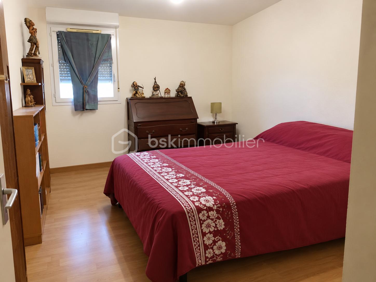 Chambre épurée au lit bordeaux.png