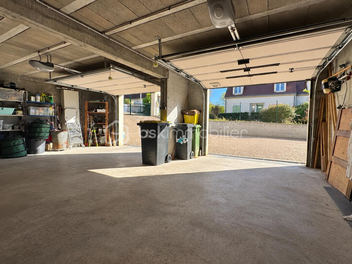 Garage ouvert sur jardin ensoleillé.png