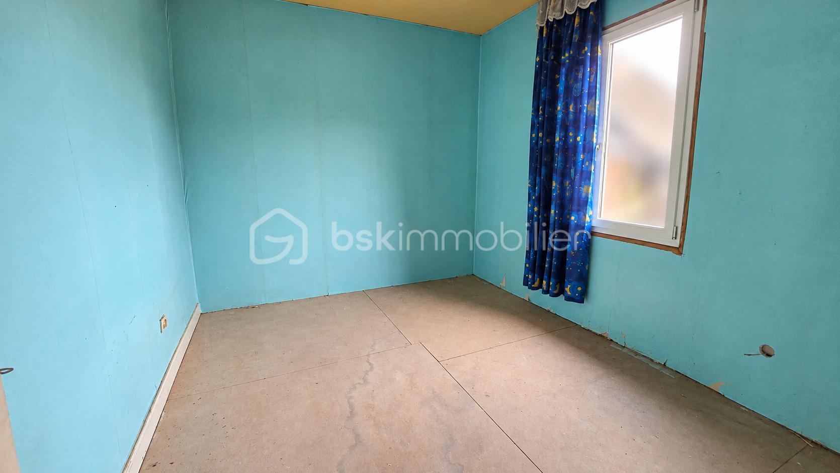 Pièce vide aux murs turquoise et rideaux étoilés.png
