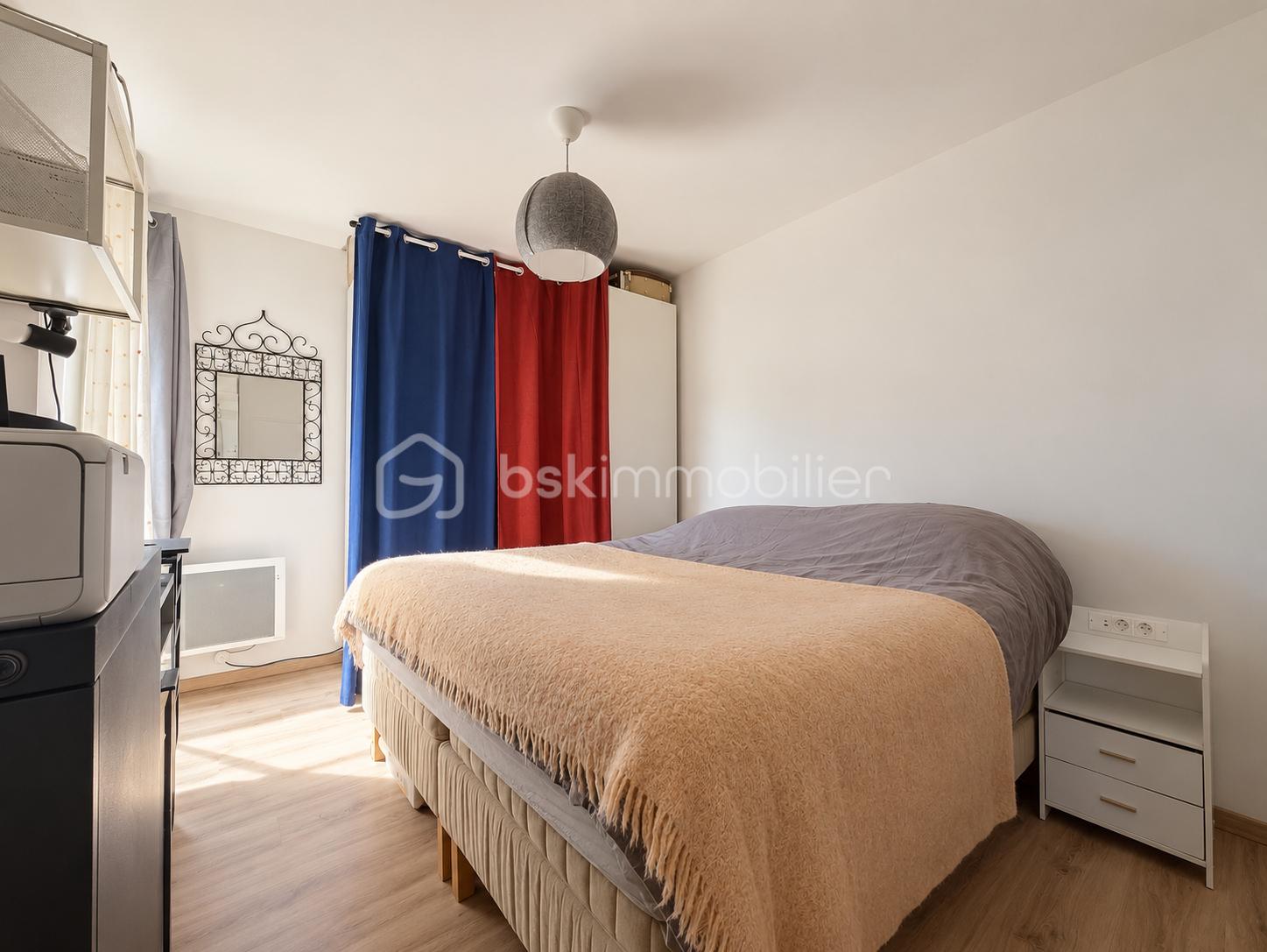Chambre minimaliste aux rideaux bleu et rouge.png
