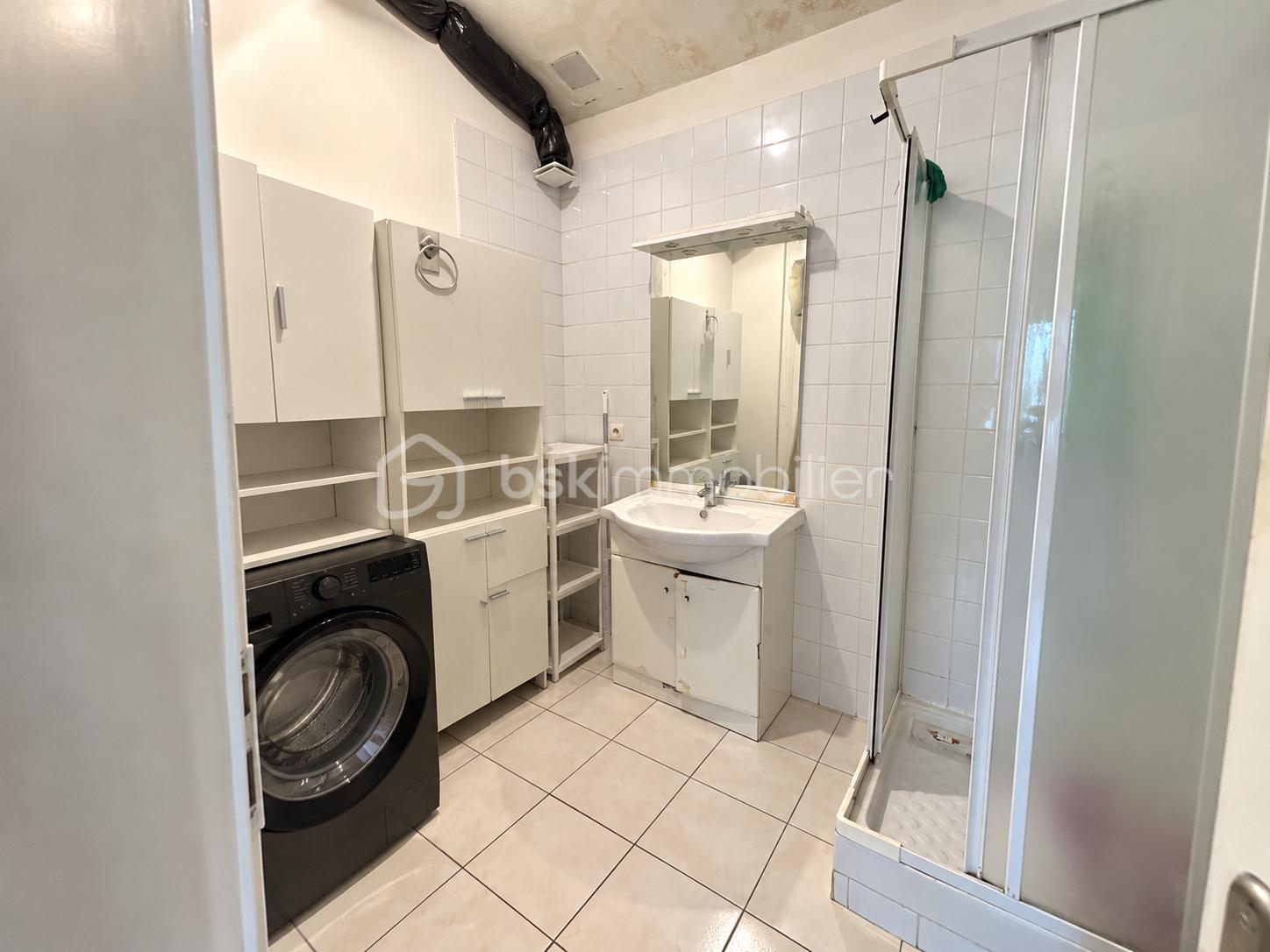 Salle de bain buanderie rangée et lumineuse.png