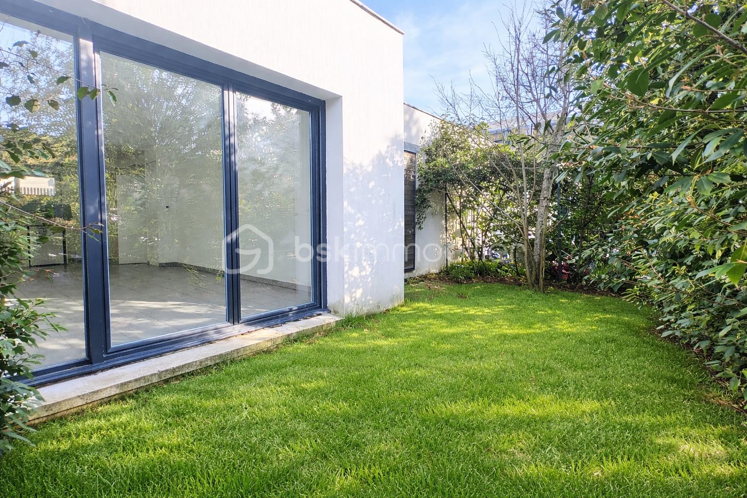 Jardin verdoyant et porte vitrée moderne.png