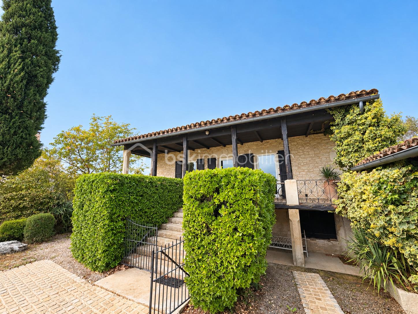 Maison en pierre sous ciel azur.png