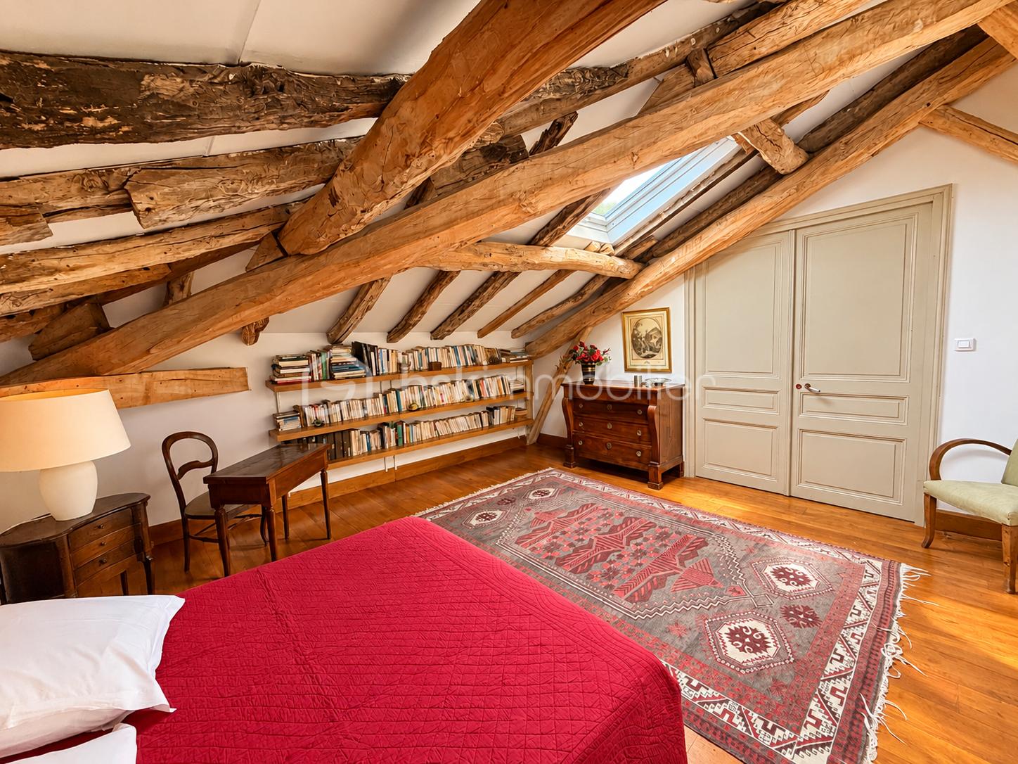 Chambre mansardée chaleureuse aux poutres anciennes.png