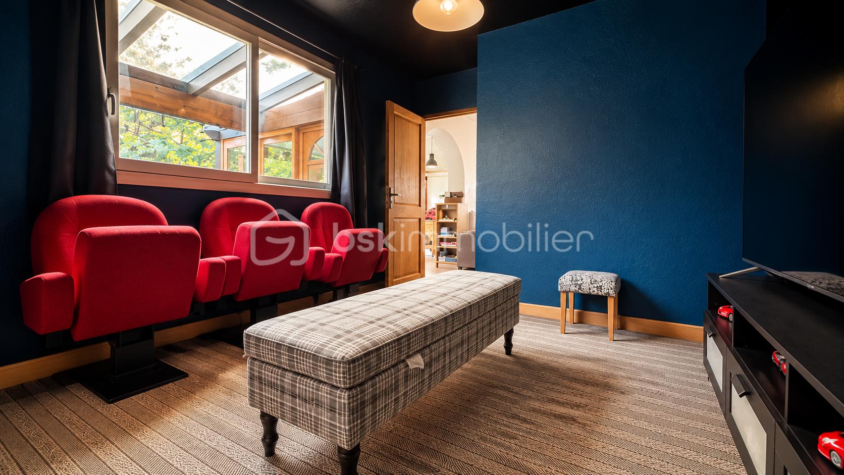 Salon home cinéma chaleureux aux murs bleu profond.png
