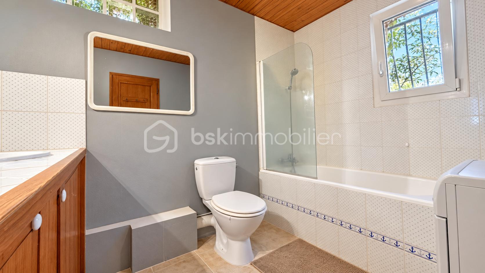 Salle de bain lumineuse aux accents bois et nautiques.png