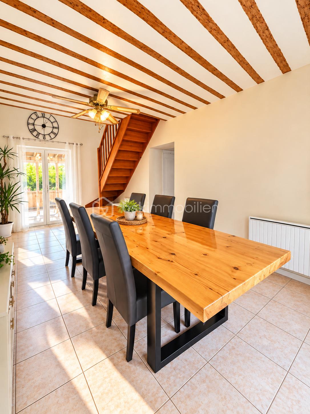 Salle à manger lumineuse aux poutres rustiques.png