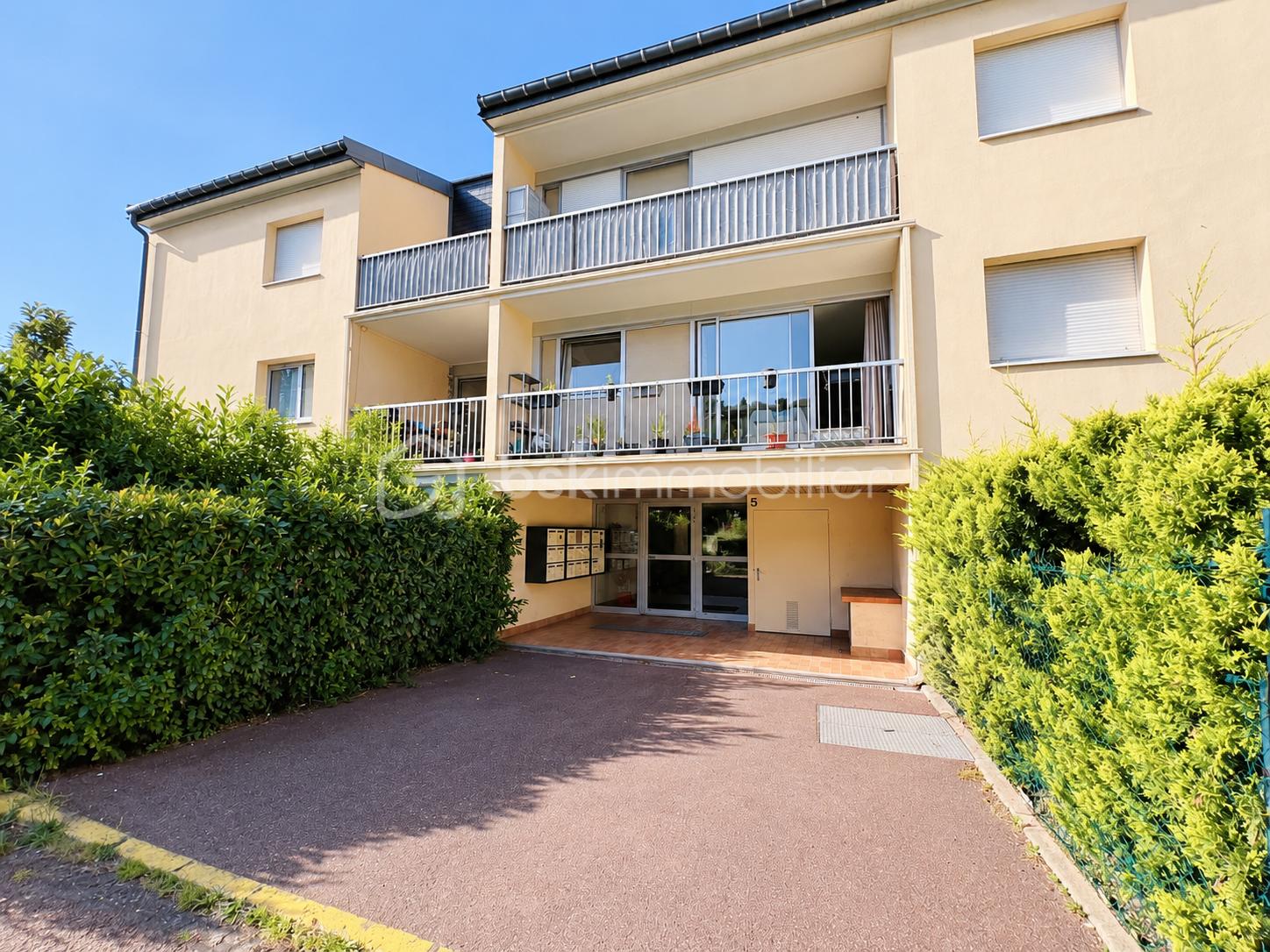 Entrée d’immeuble beige sous ciel bleu.png