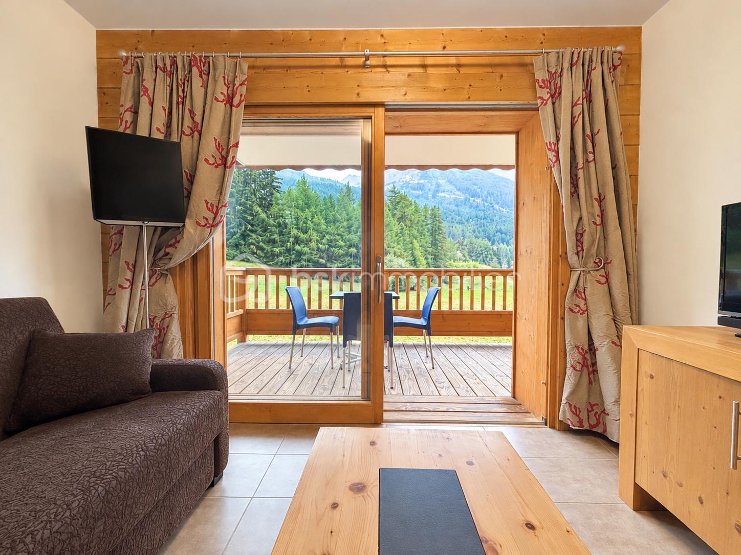 Salon chalet lumineux avec vue montagne.png