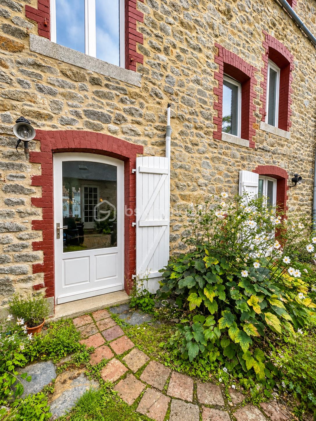 Maison en pierre et jardin fleuri.png