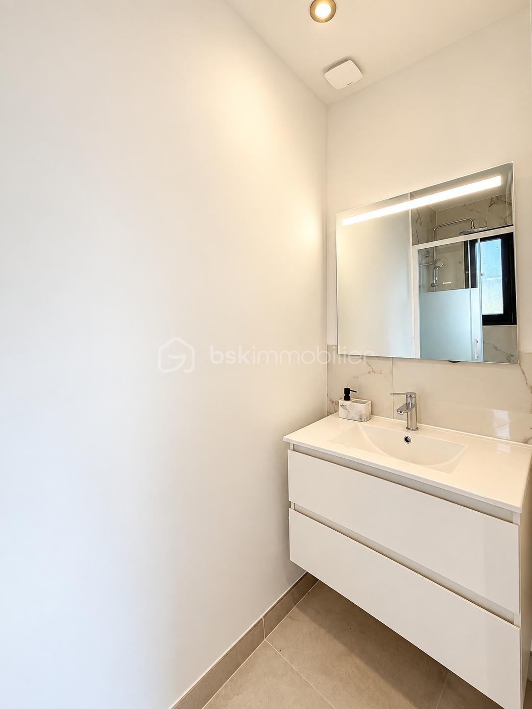 Salle de bain minimaliste avec miroir lumineux.png