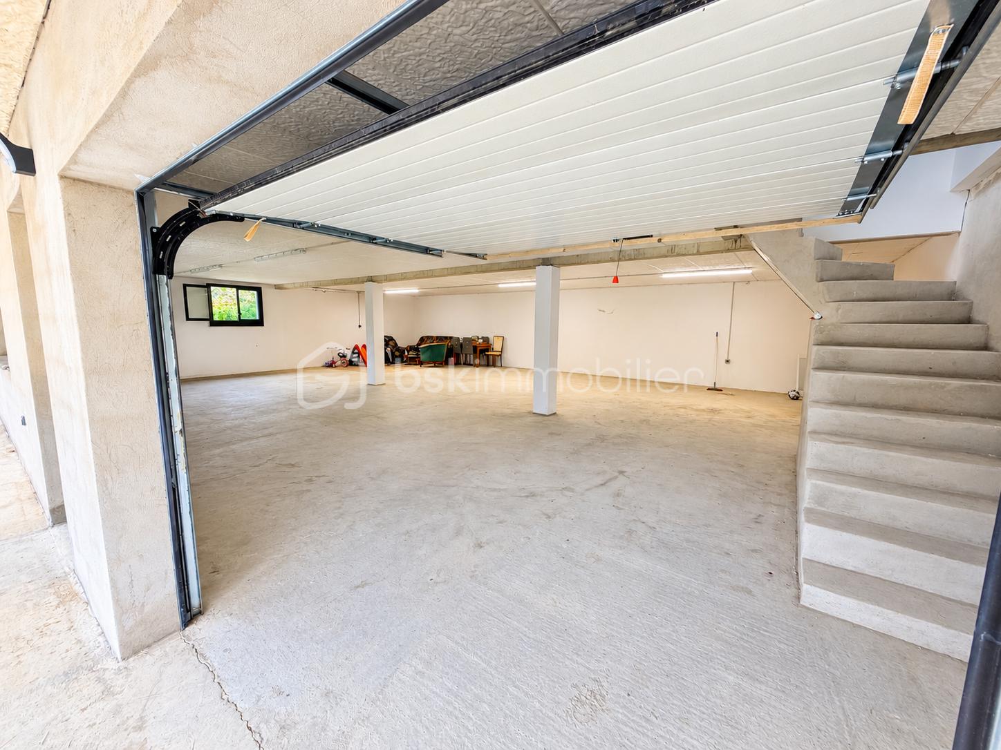 Grand garage lumineux avec escalier en béton.png