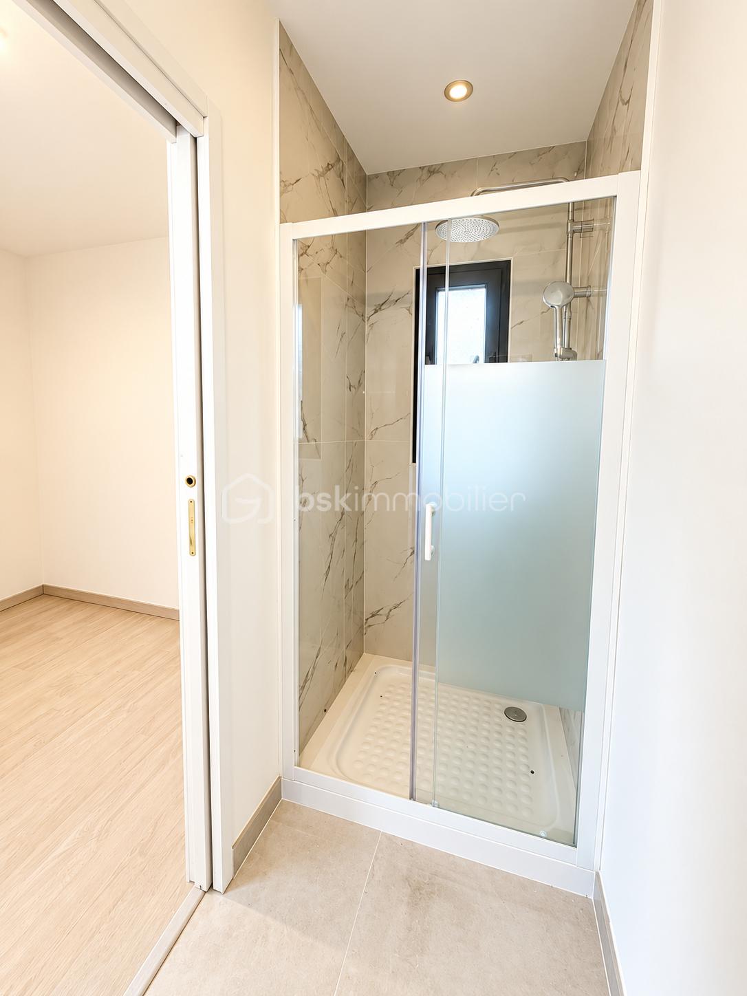 Salle de bain moderne avec douche vitrée.png