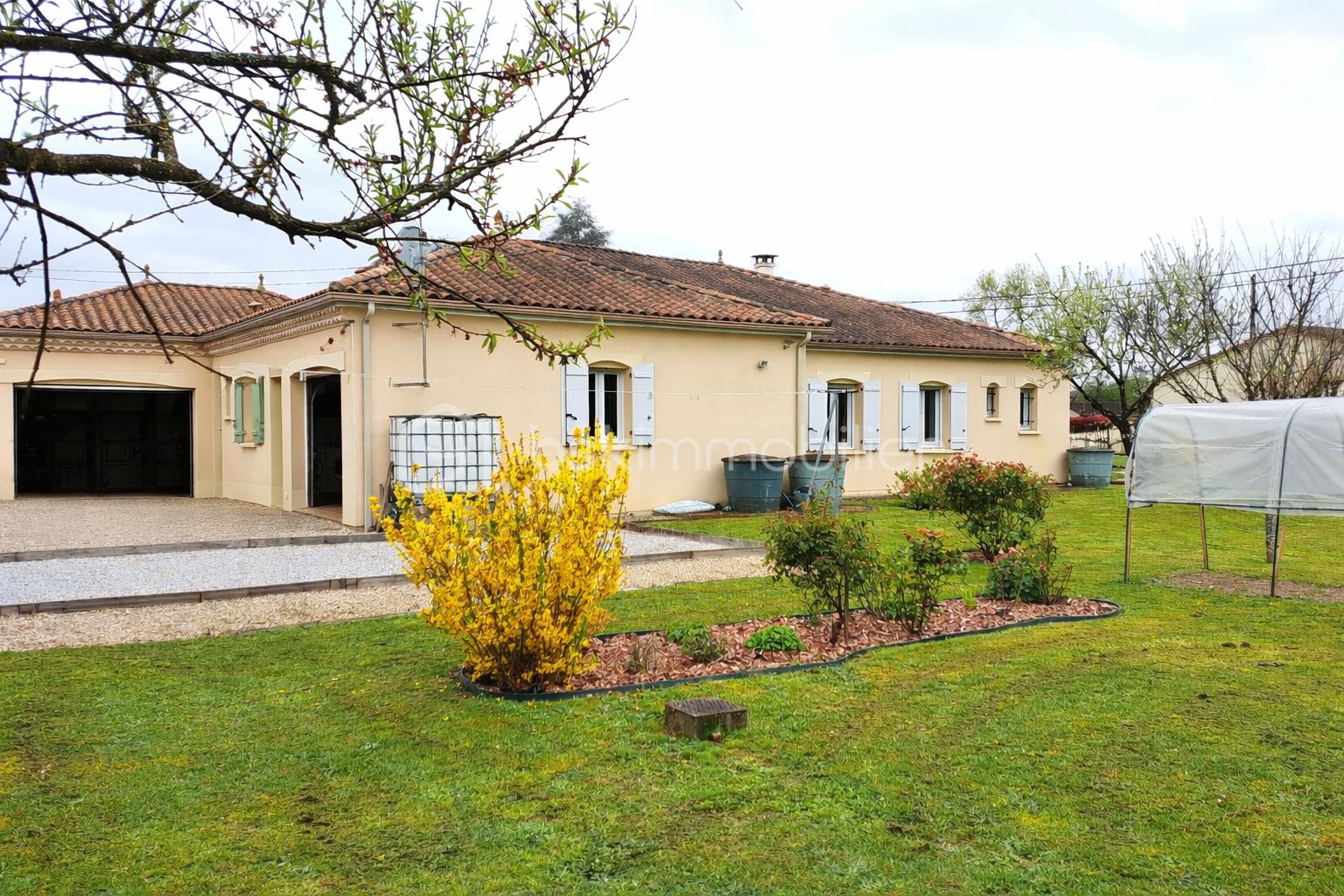 Maison beige et jardin lumineux.png