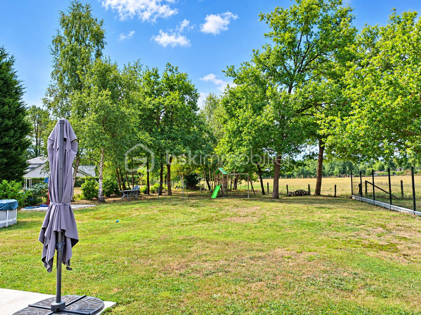 Jardin estival avec parasol et aire de jeux.png