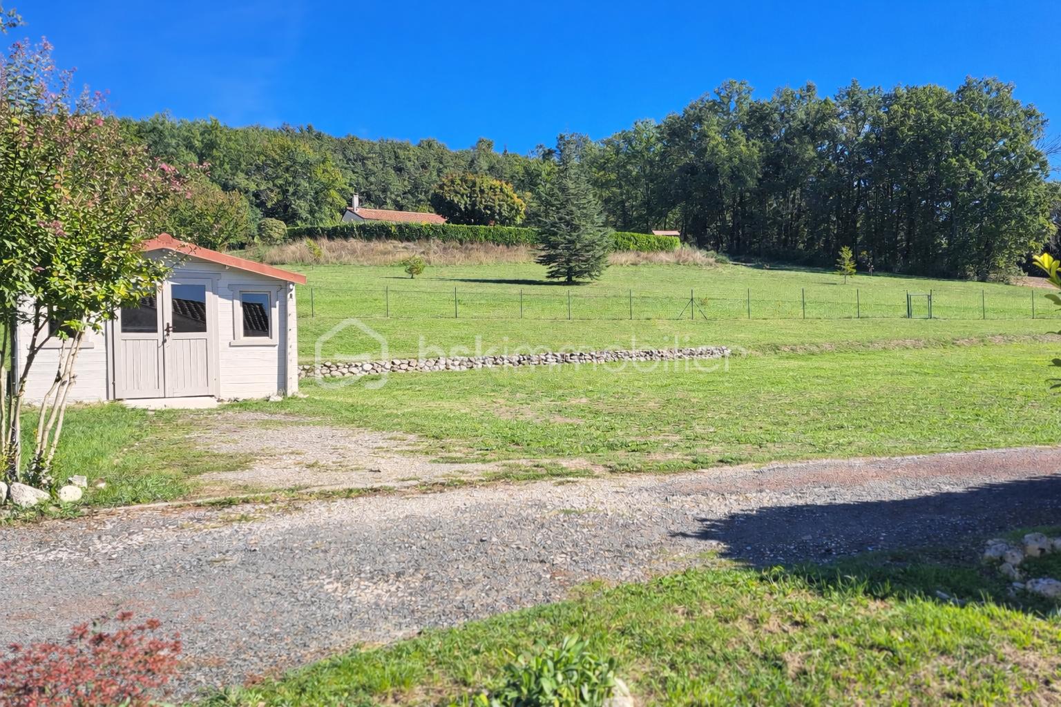 Maison de 70 m² - Paysage ensoleillé avec cabanon et forêt.png