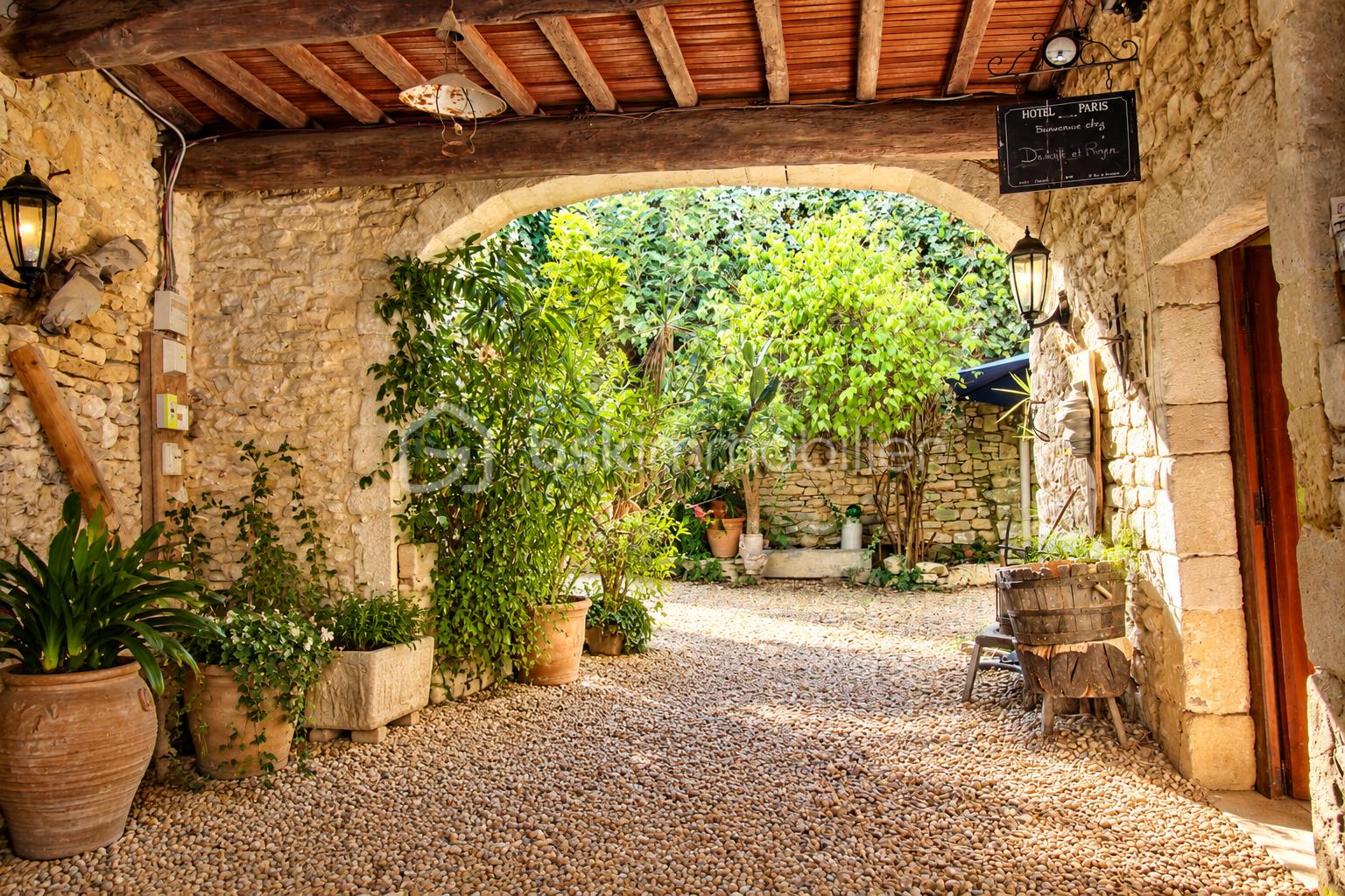 Passage en pierre vers un jardin provençal.png
