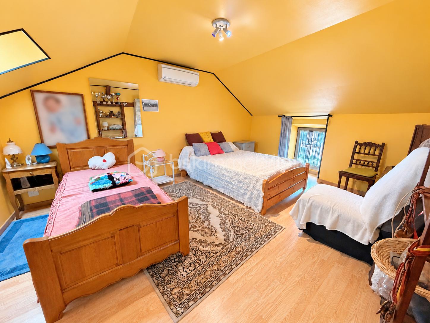 Chambre mansardée jaune aux portraits floutés.png