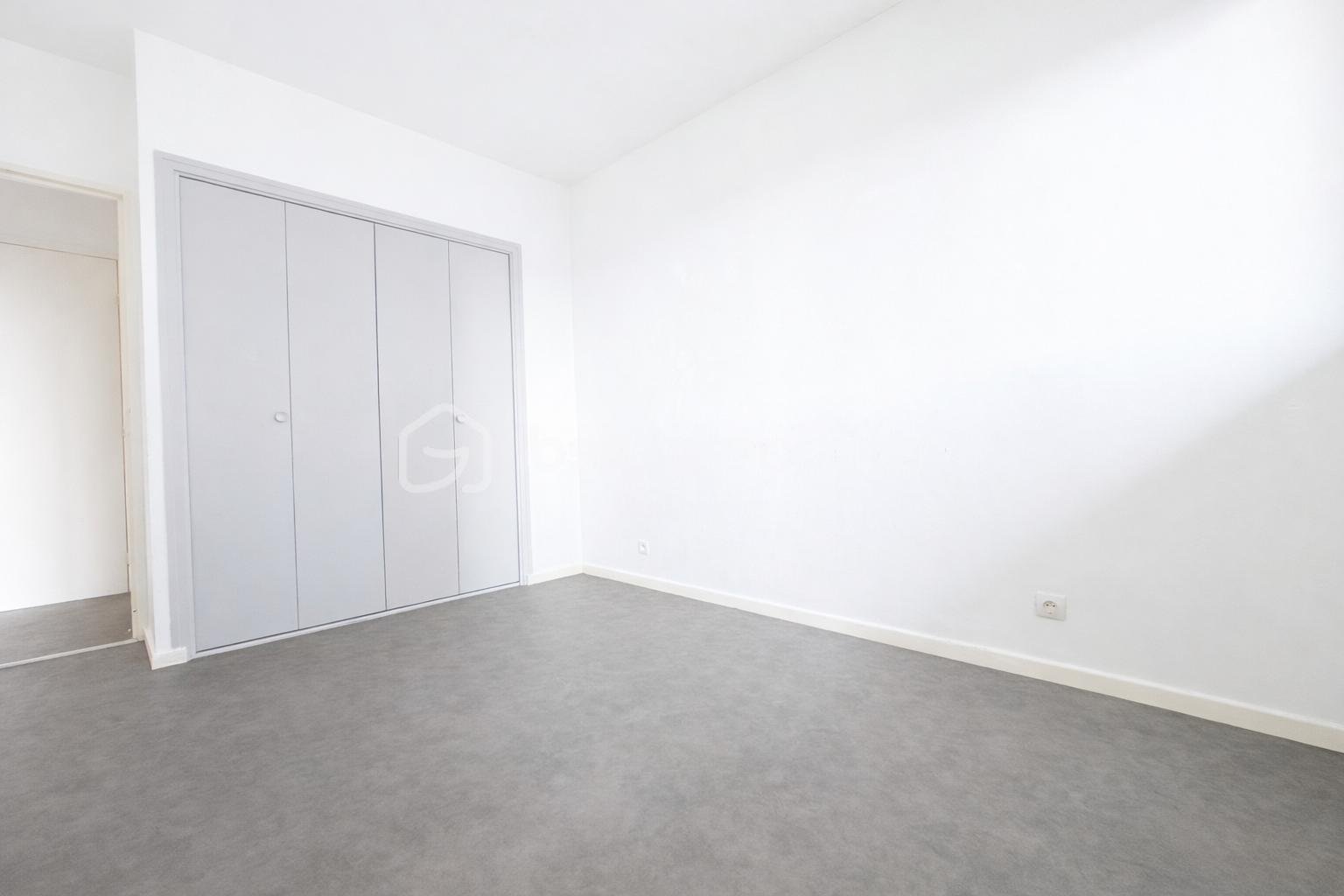 Appartement de 35 m² - Chambre vide avec portes de placard.png