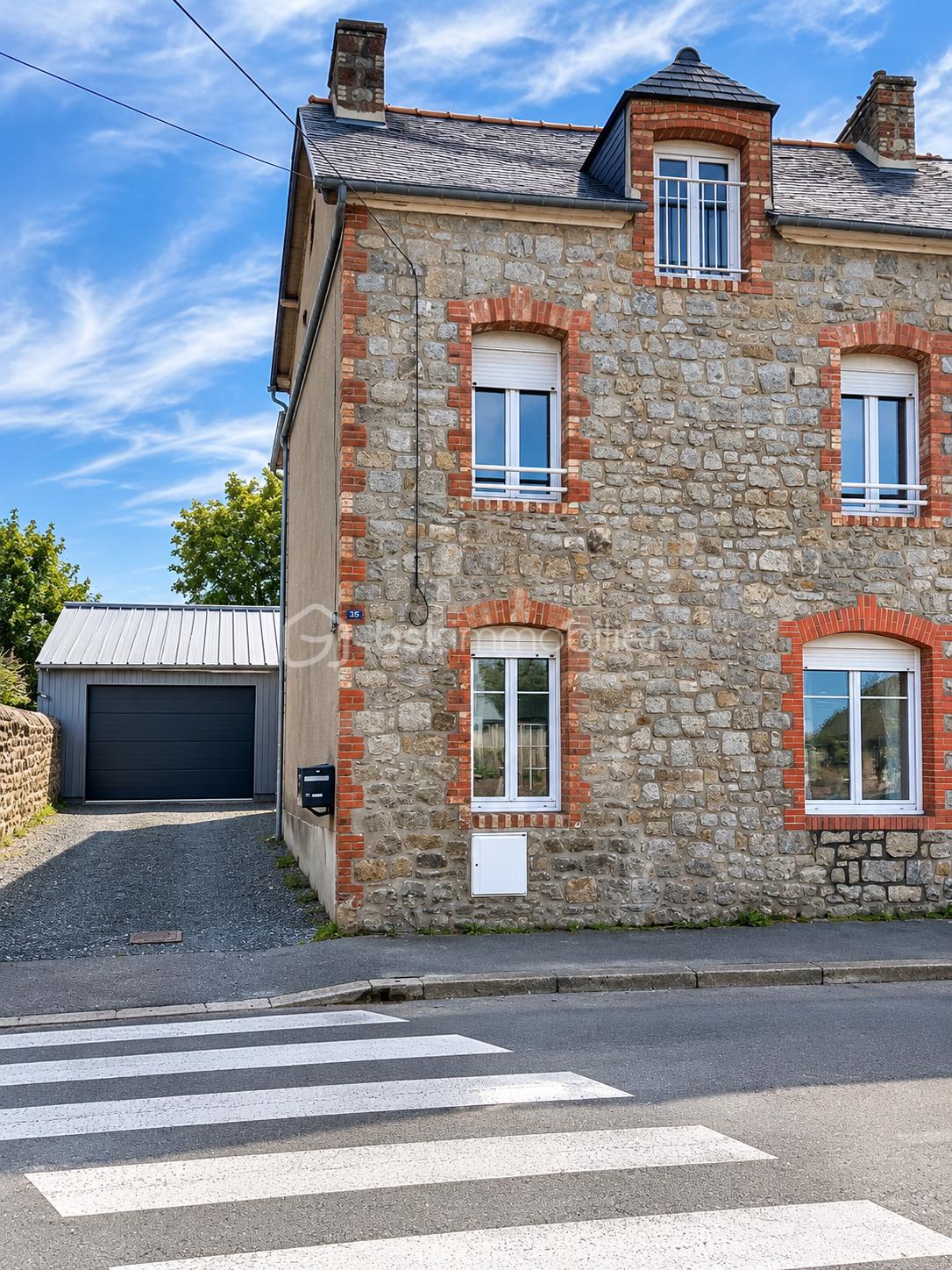 Façade de maison en pierre sous ciel bleu.png