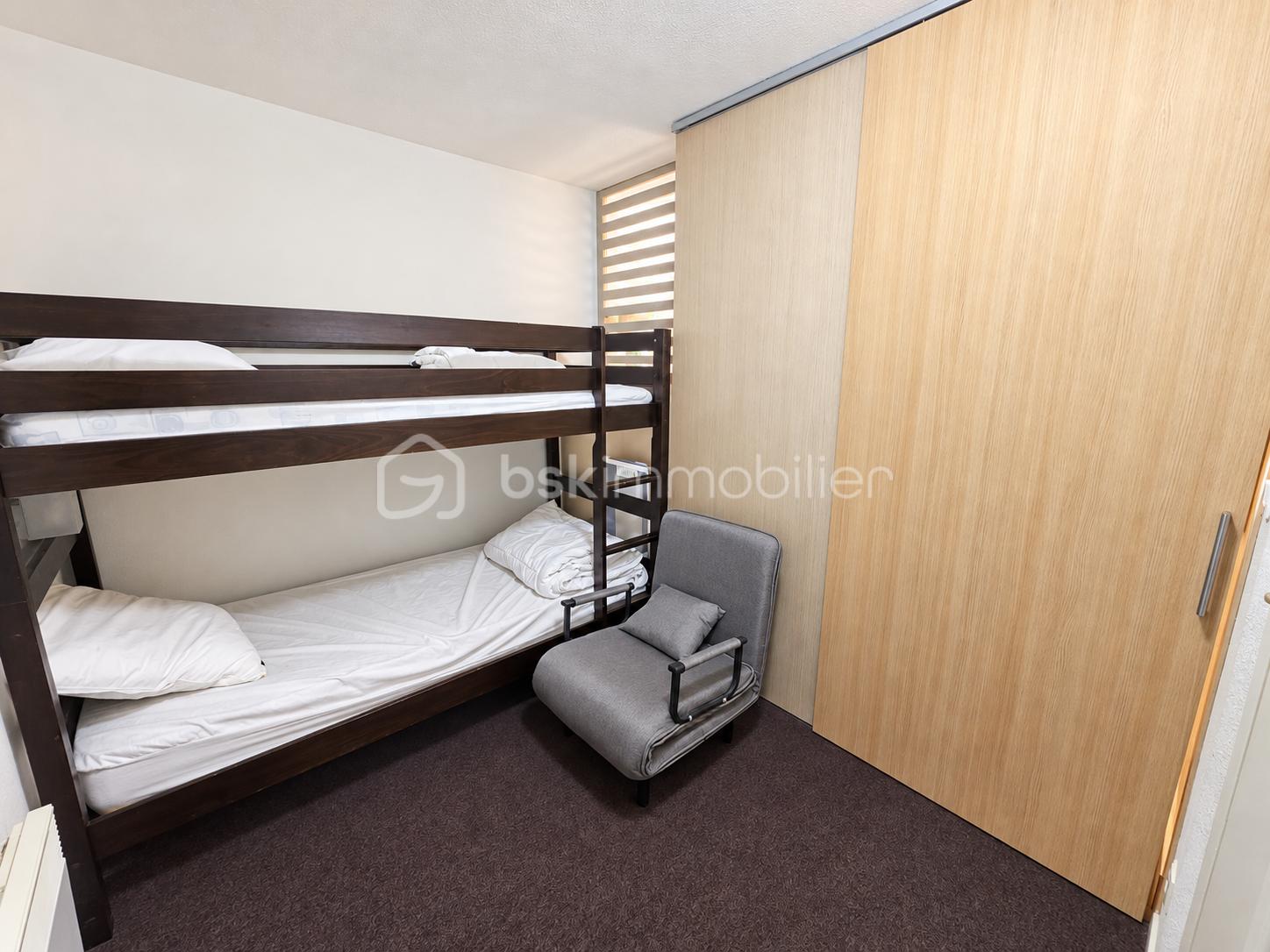 Chambre moderne avec lit superposé et dressing en bois clair.png