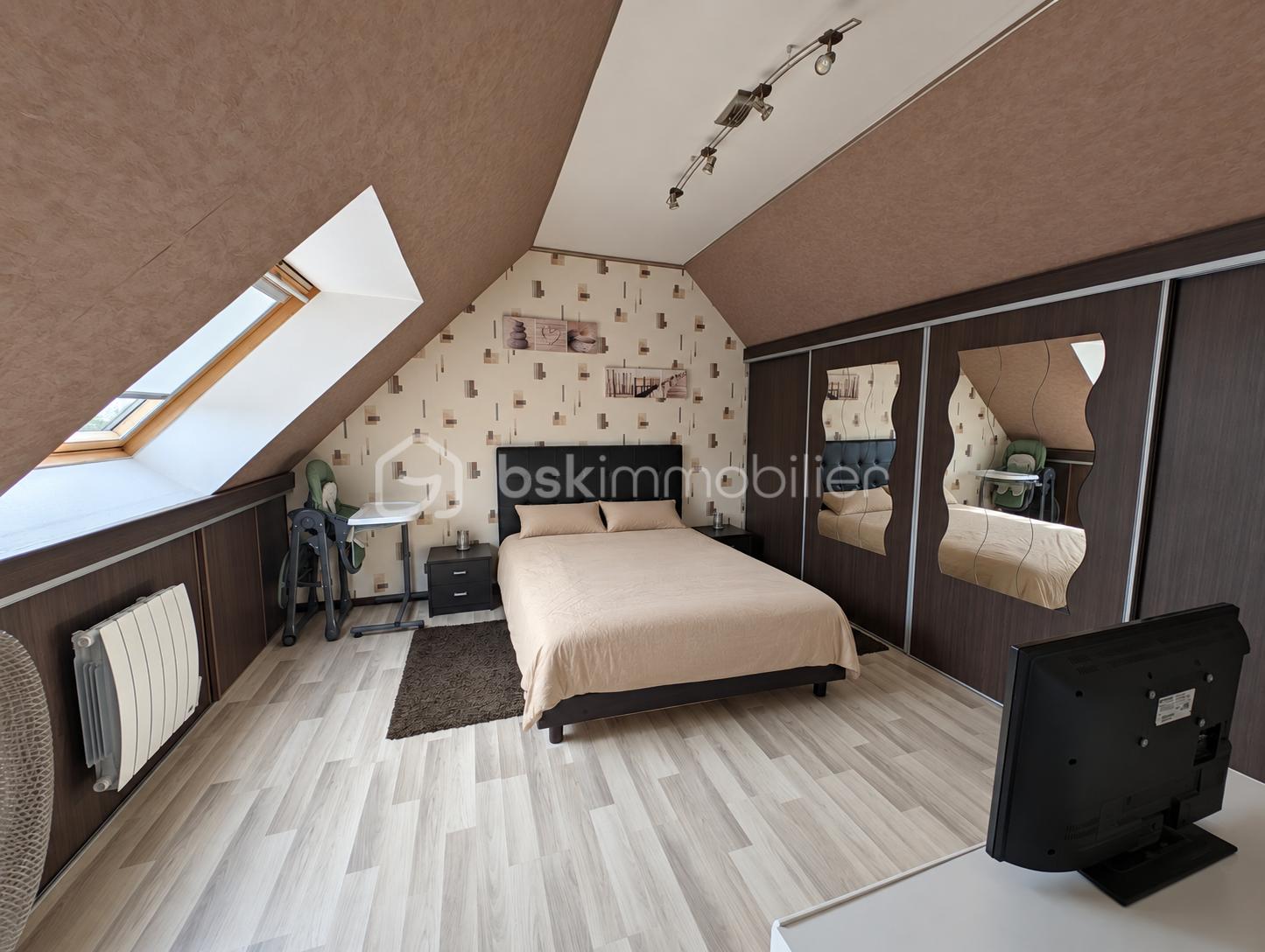 Chambre mansardée rangée et lumineuse.png