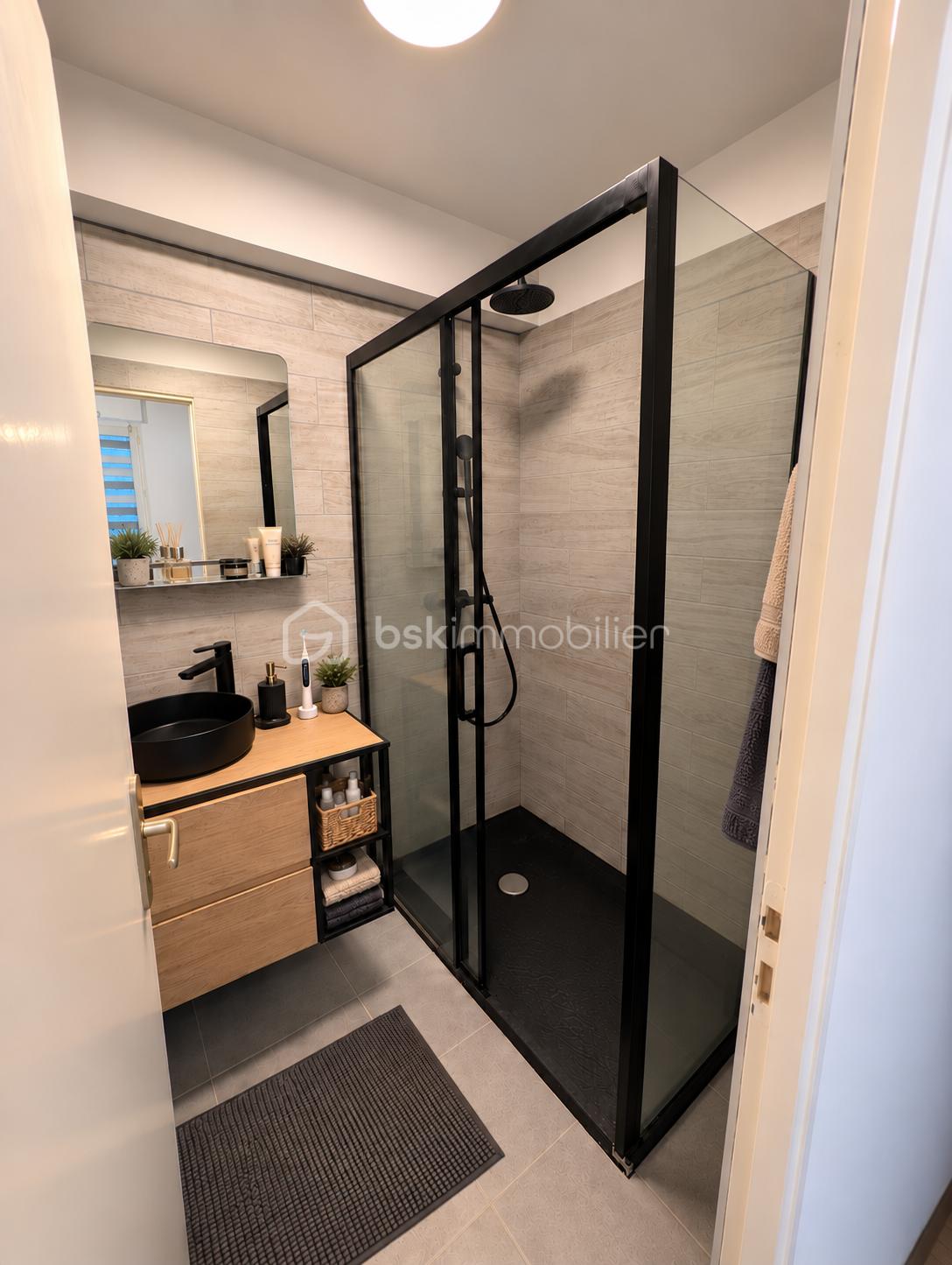 Salle de bains scandinave chaleureuse avec douche noire.png