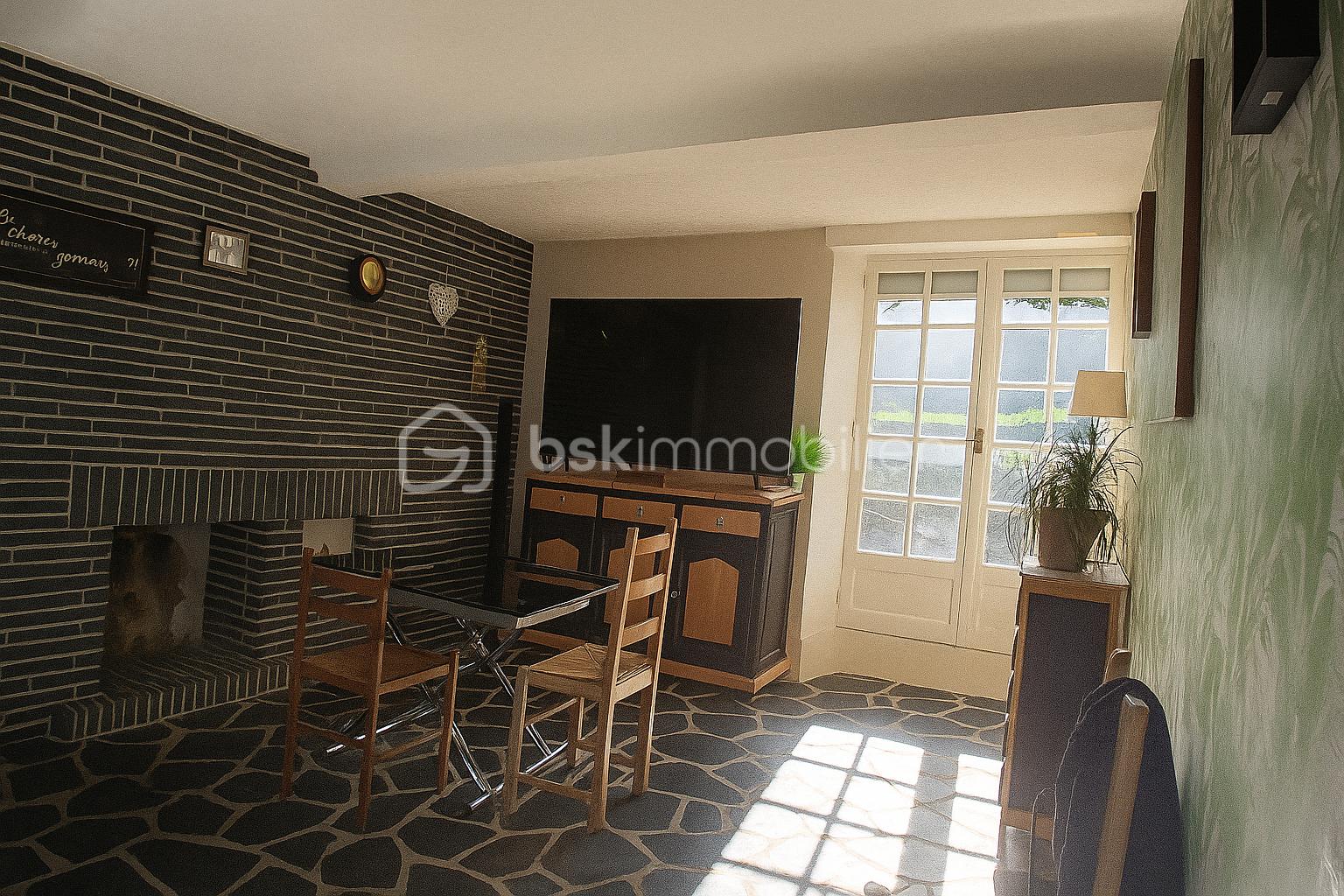 Maison en pierre de 139,50 m² - Salon lumineux et chaleureux avec cheminée.png