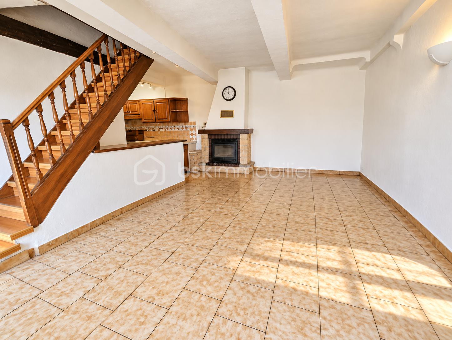 Salon ouvert lumineux avec cheminée et escalier en bois.png