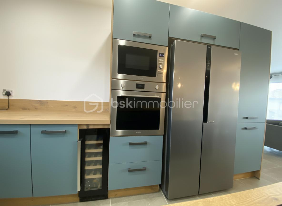 Maison de 125 m² - Cuisine vue sur cave à vin four micro onde et frigo americain.jpg