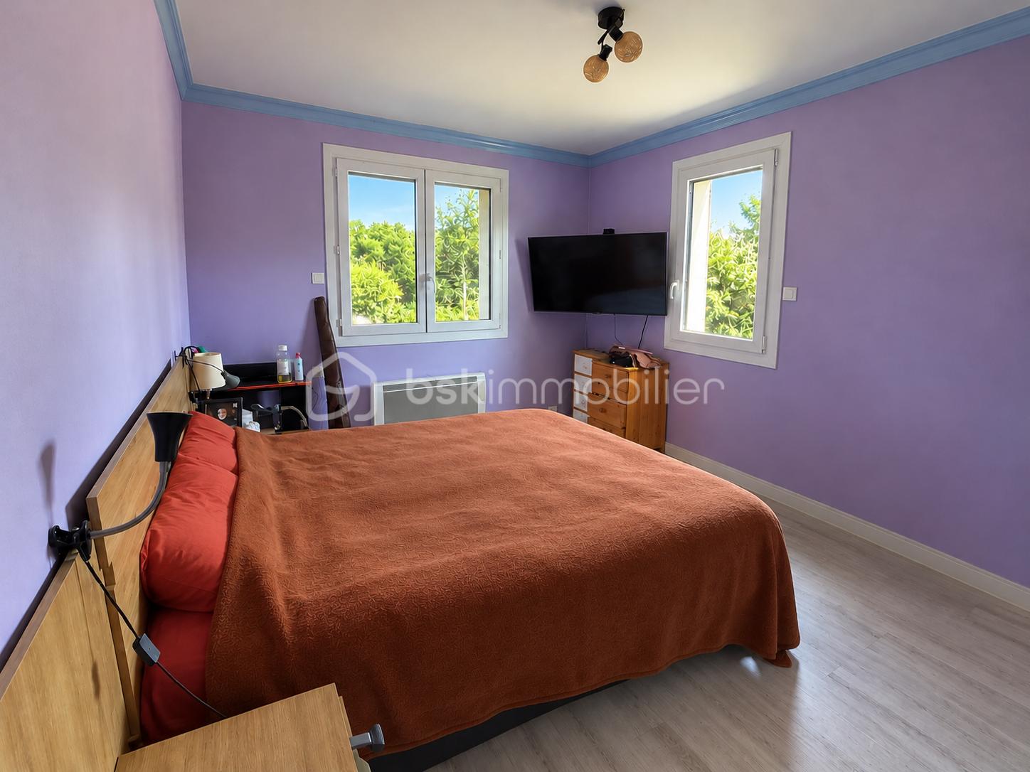 Chambre violette avec lit orange ordonné.png