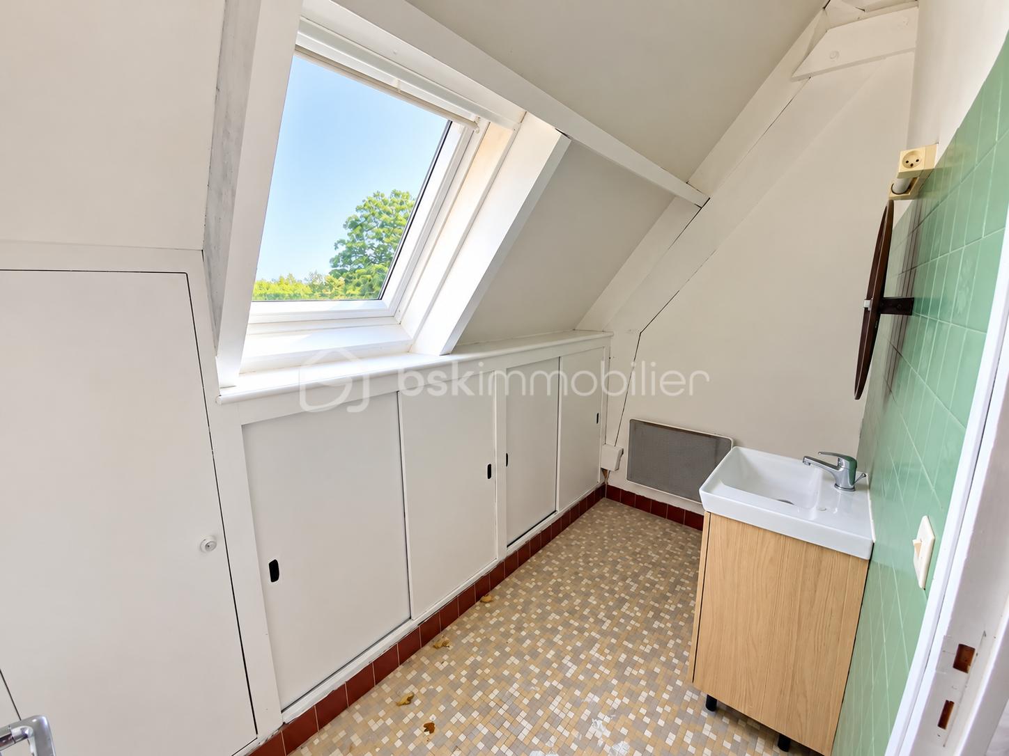Salle de bain mansardée baignée de lumière.png