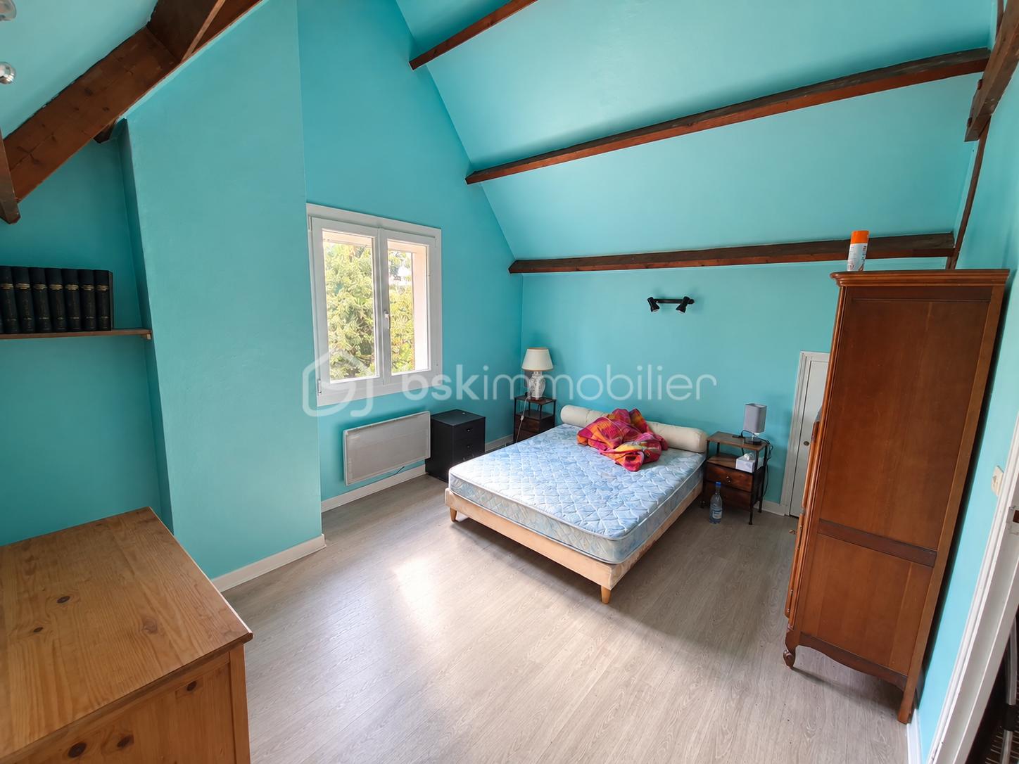 Chambre mansardée turquoise baignée de lumière.png