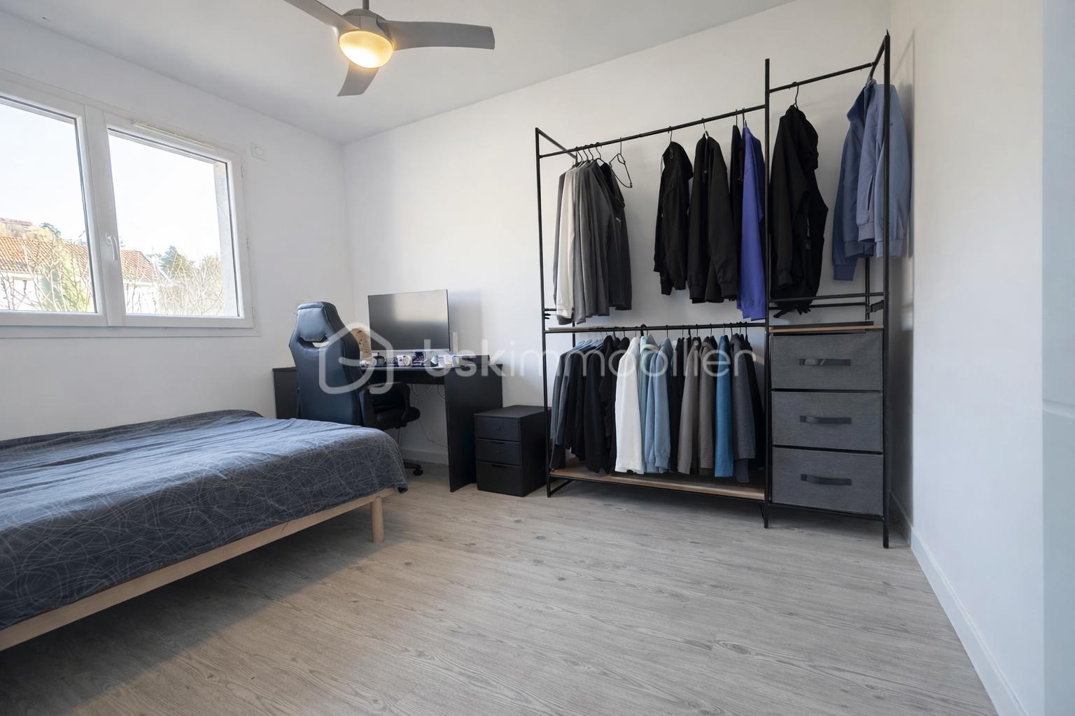 Maison de 91 m² - Chambre moderne et épurée sous lumière naturelle.png