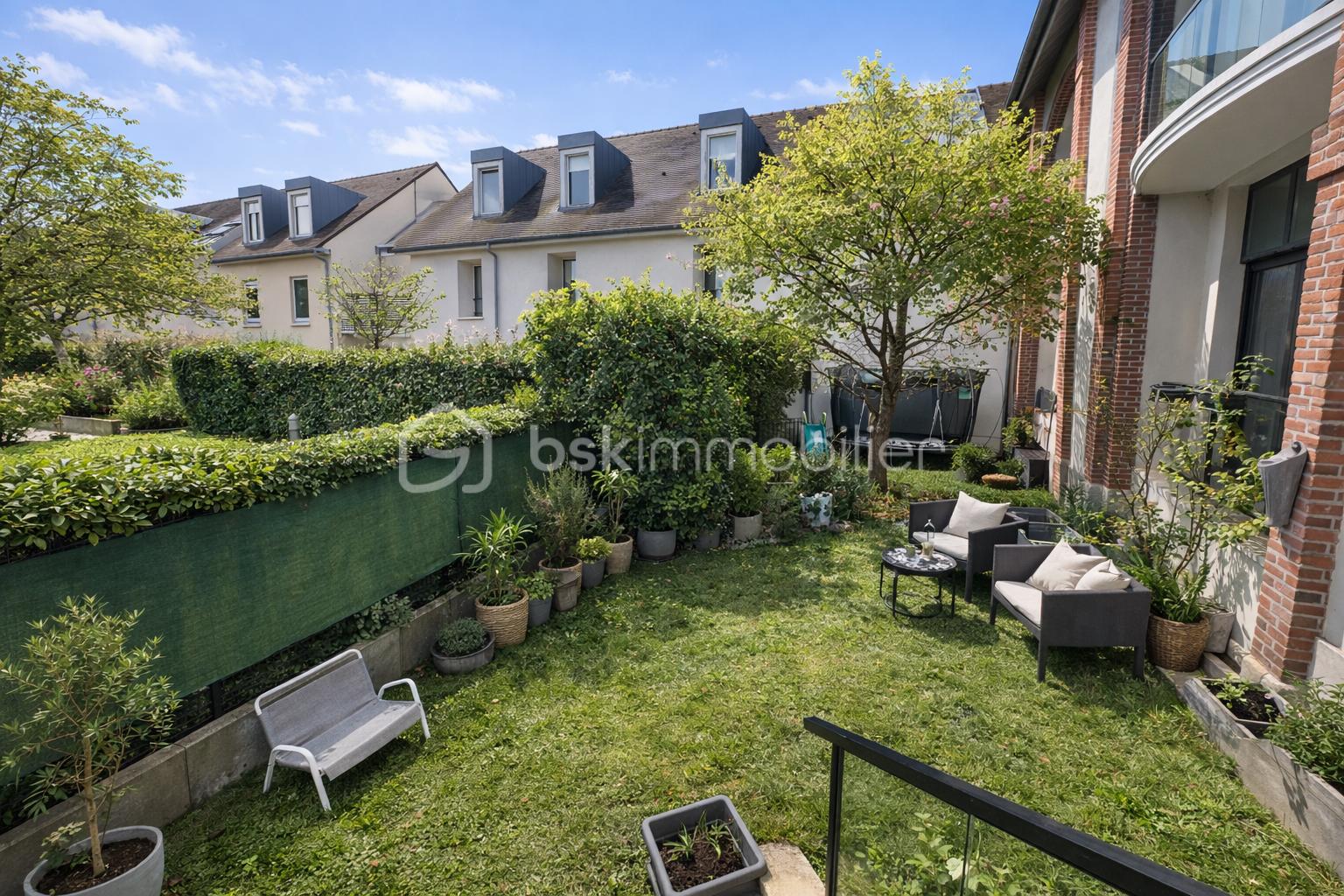 Jardin ensoleillé avec fauteuils et plantes.jpeg