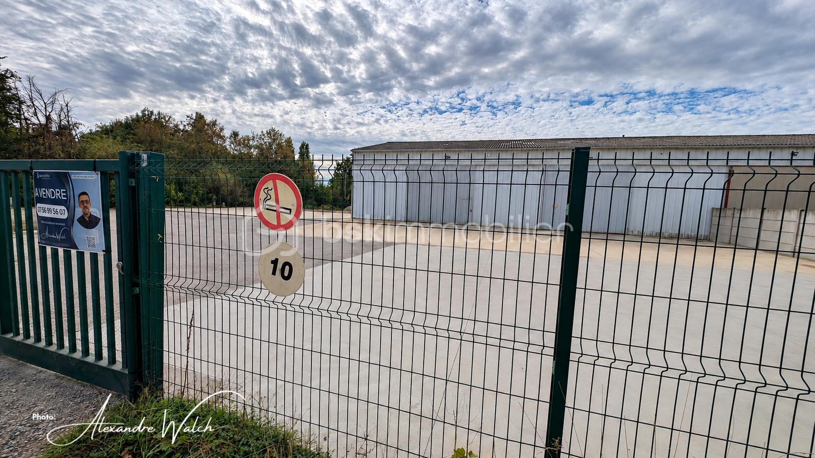 signatureEntrepôt industriel derrière clôture.jpg