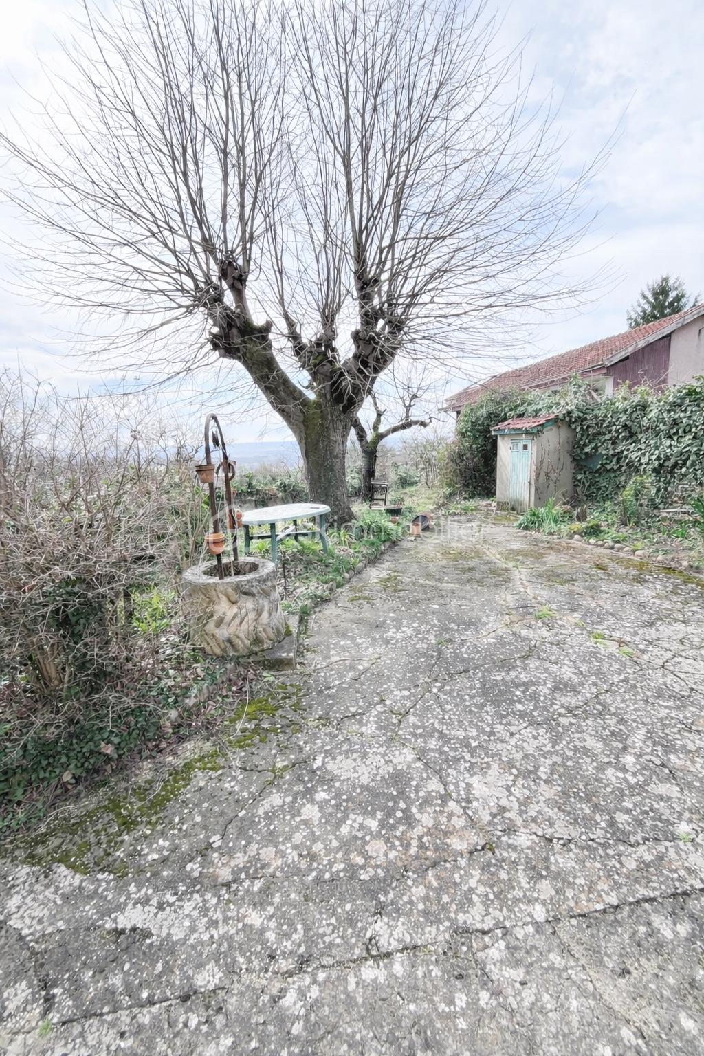 Maison de village de 155 m² - Courtyard ancien sous un ciel nuageux.png