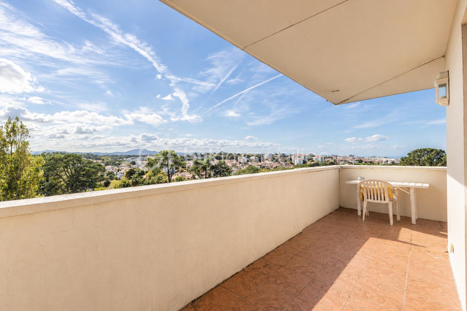 Balcon ensoleillé avec vue panoramique.png