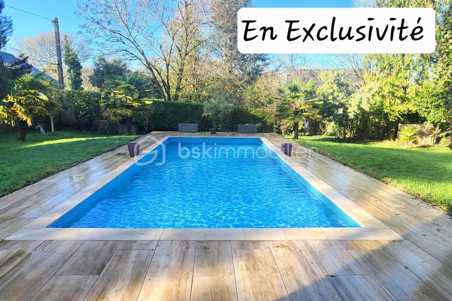 Propriete de 230,14 m² - Piscine entourée de verdure ensoleillée.png