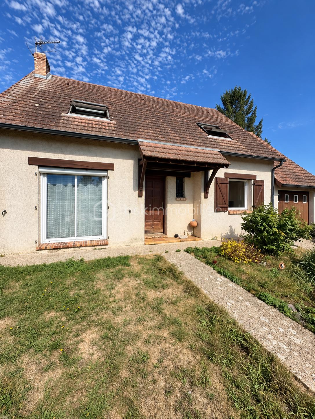 Maison beige au ciel azur.png