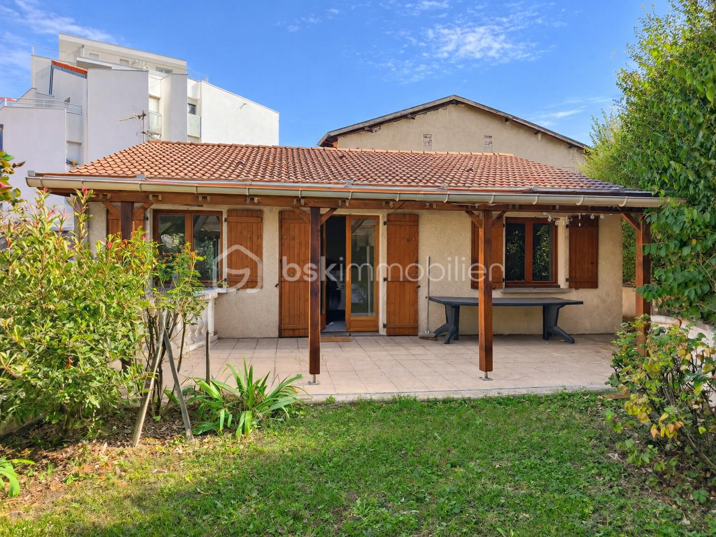 Maison ensoleillée avec patio fleuri.png