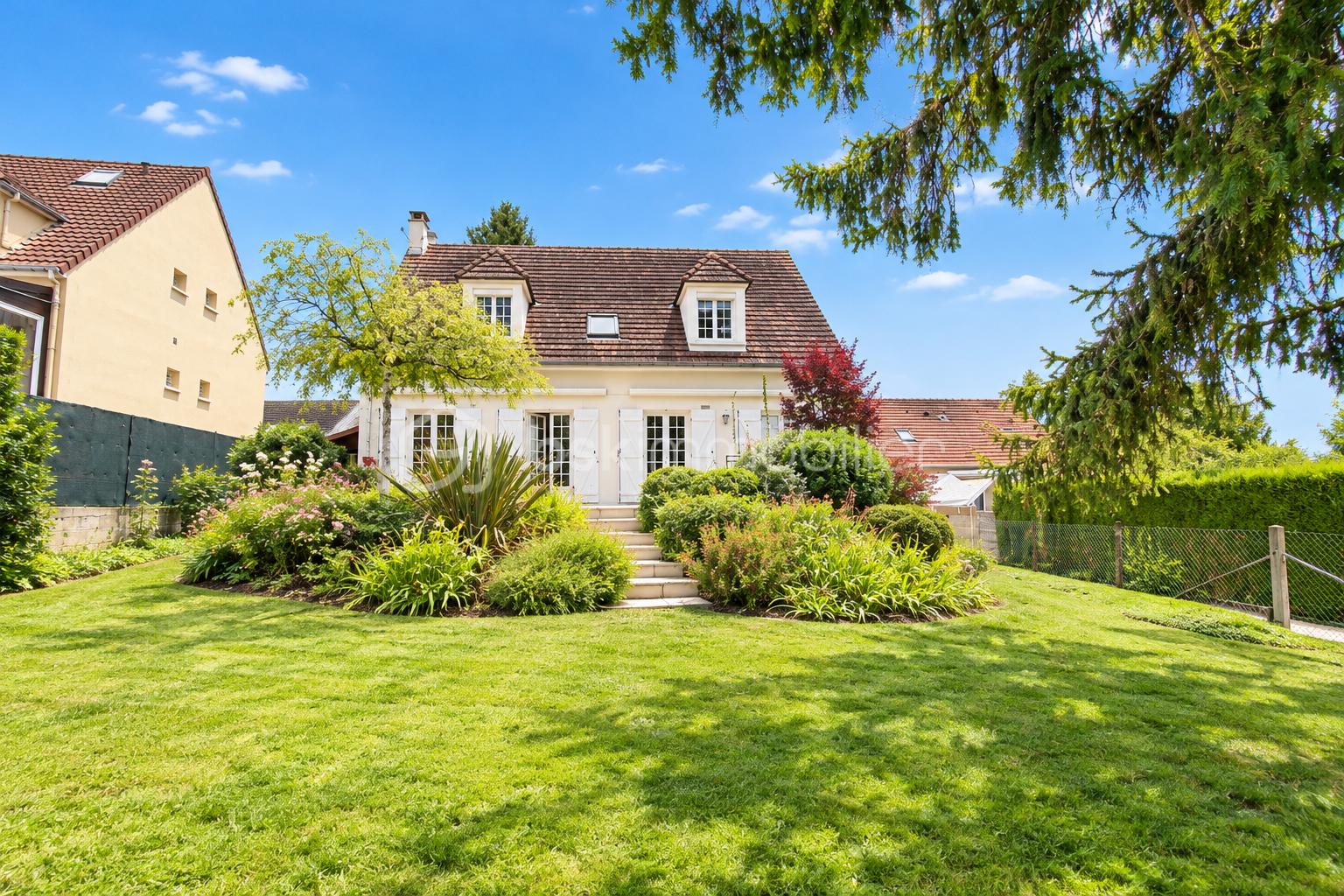 Maison crème et jardin fleuri ensoleillé.png