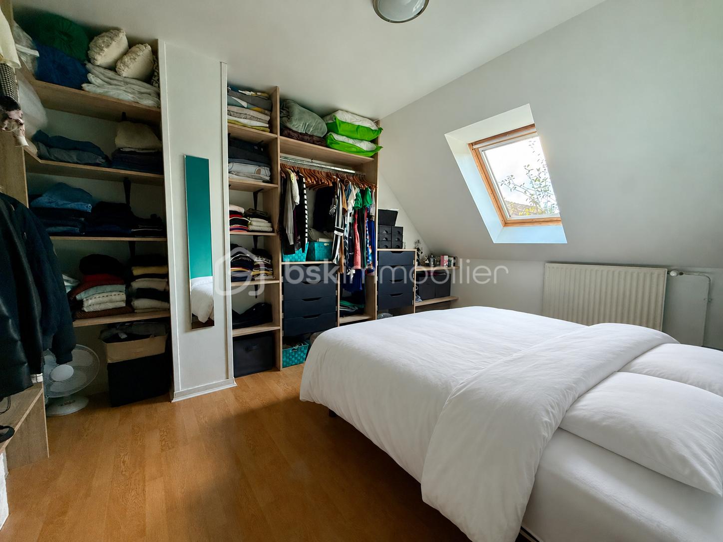 Chambre mansardée avec lit blanc immaculé.png