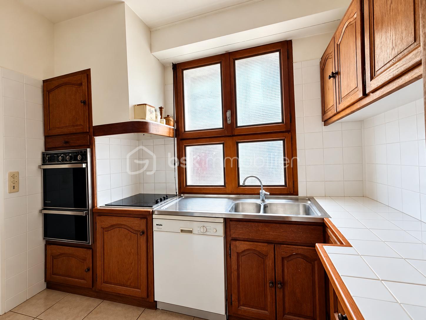 Cuisine traditionnelle en bois et carrelage blanc.png