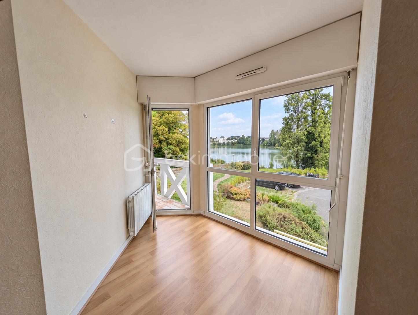 Intérieur lumineux, vue sur étang et jardin.png