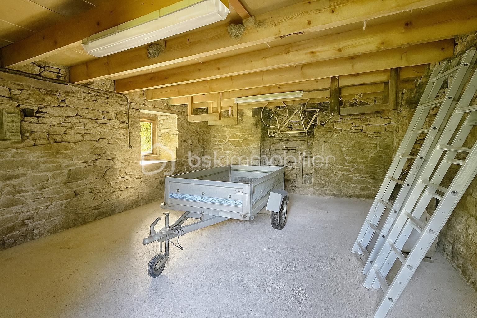 Maison de 101 m² - Garage rustique aux matériaux traditionnels.png
