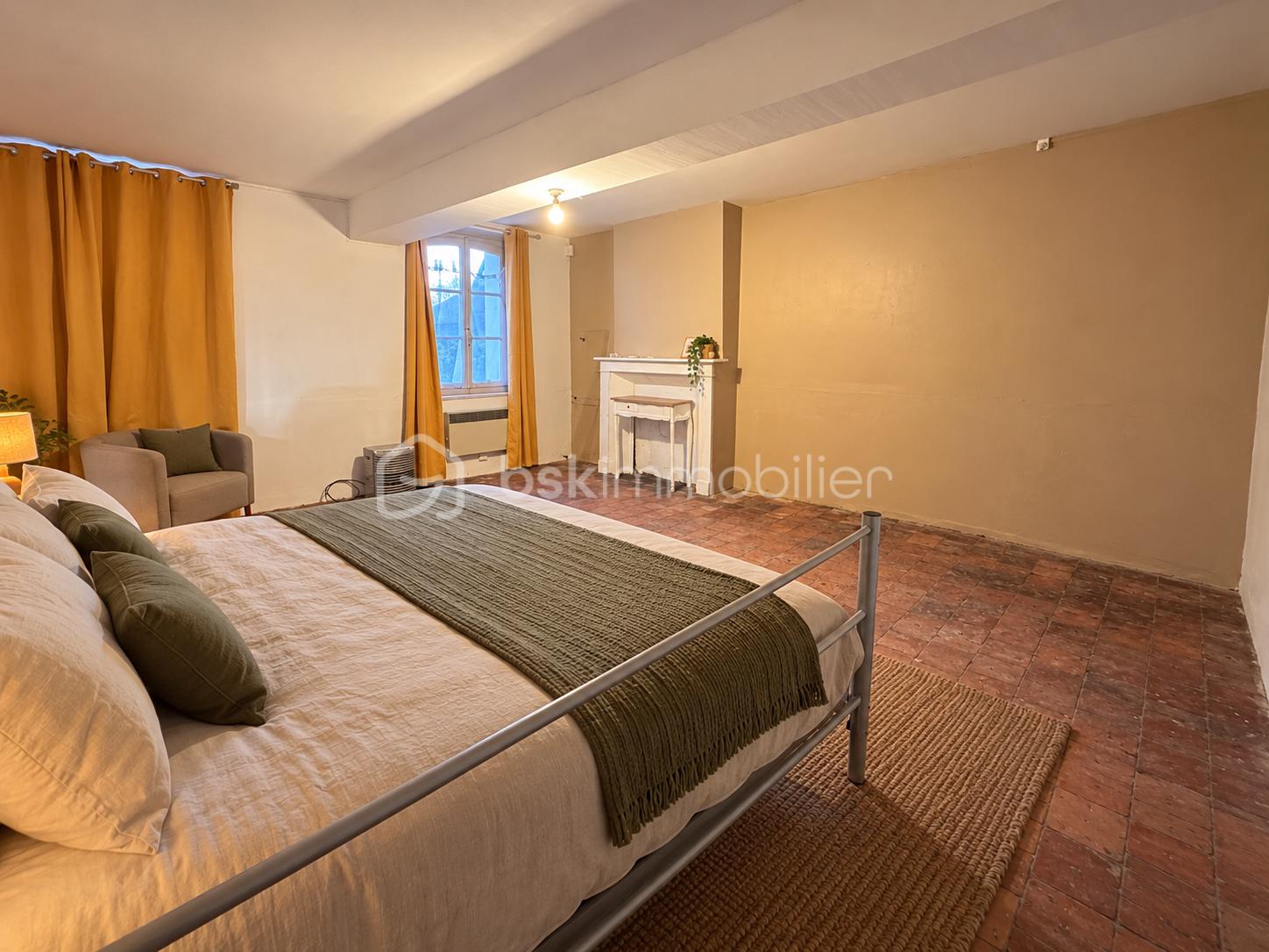 Chambre rustique chaleureuse avec lit et cheminée.png