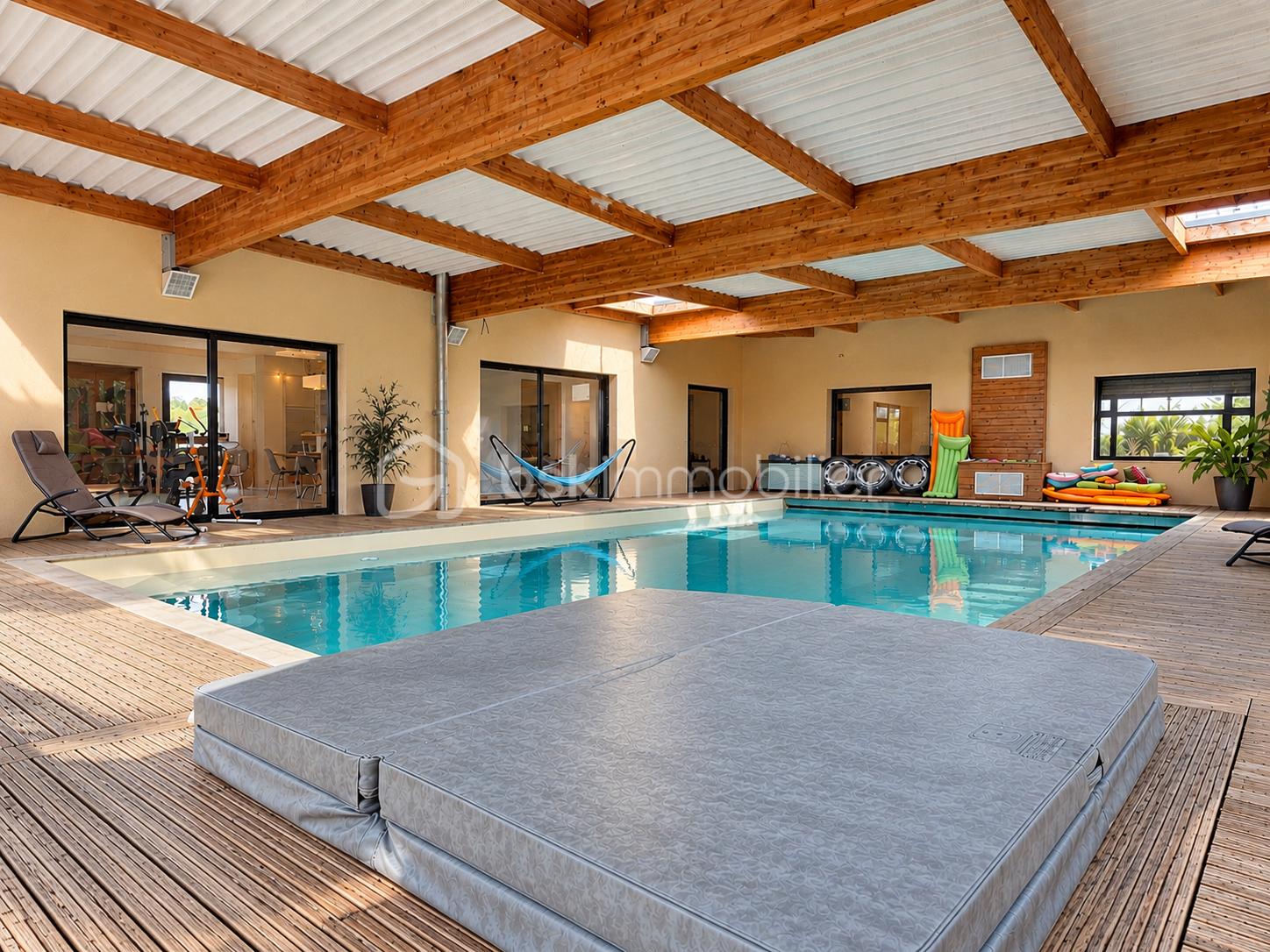 Piscine intérieure lumineuse aux poutres apparentes.png